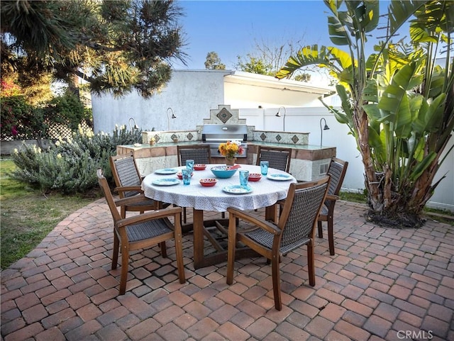 view of patio / terrace featuring grilling area, outdoor dining space, and exterior kitchen