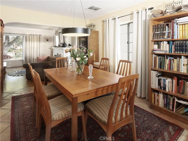 dining space with light tile patterned floors and visible vents