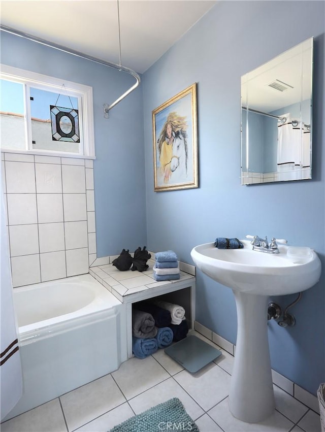 bathroom featuring tile patterned floors, visible vents, and a bathtub