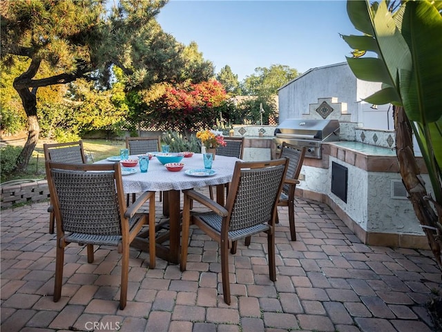 view of patio / terrace featuring a grill, outdoor dining space, visible vents, and exterior kitchen
