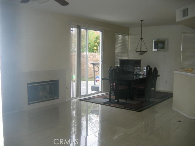 1590 River Wood Ct, Simi Valley, CA 93063 - dining area featuring a fireplace, a ceiling fan, visible vents, tile patterned flooring, and baseboards