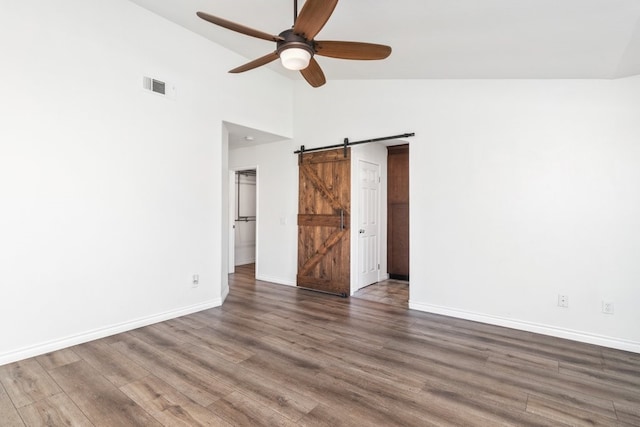 39203 Foxglove Cir, Murrieta, CA 92563 - unfurnished bedroom featuring baseboards, a barn door, visible vents, high vaulted ceiling, and wood finished floors