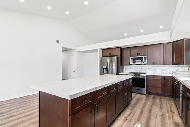 39203 Foxglove Cir, Murrieta, CA 92563 - kitchen with tasteful backsplash, light wood-type flooring, visible vents, a kitchen island, and appliances with stainless steel finishes