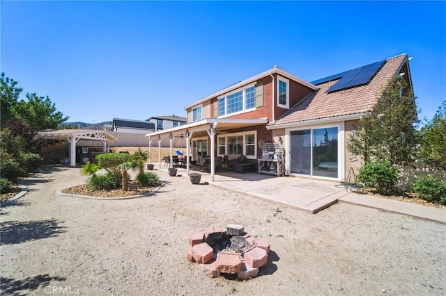 41908 Sonoma Rd, Palmdale, CA 93551 - back of house with roof mounted solar panels, a patio, a pergola, a fire pit, and stucco siding