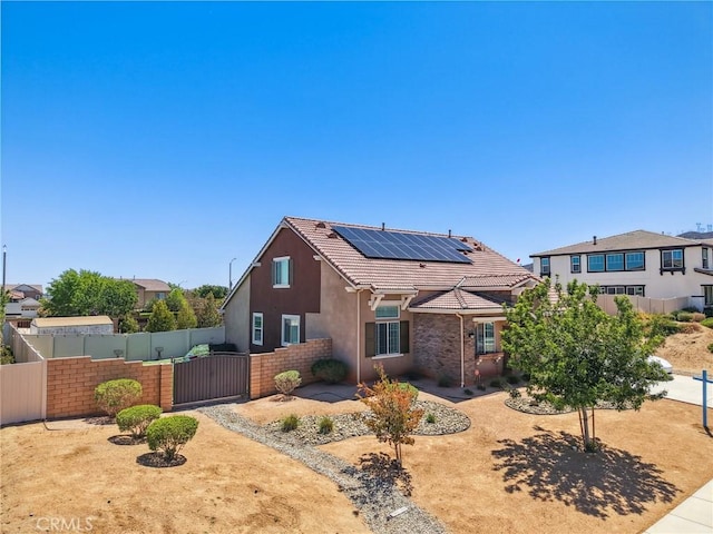41908 Sonoma Rd, Palmdale, CA 93551 - view of front of house featuring a gate, roof mounted solar panels, stucco siding, and a tiled roof