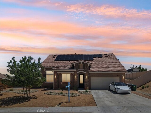41908 Sonoma Rd, Palmdale, CA 93551 - view of front of property with a garage, a tile roof, concrete driveway, solar panels, and stucco siding