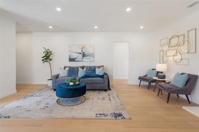 living room with baseboards, recessed lighting, visible vents, and light wood-style flooring