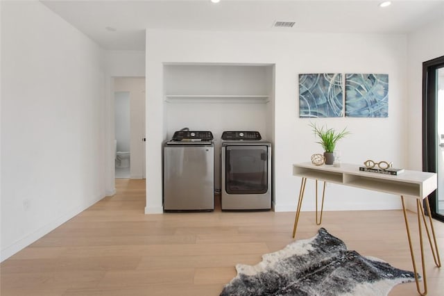 clothes washing area with separate washer and dryer, light wood-type flooring, laundry area, visible vents, and recessed lighting
