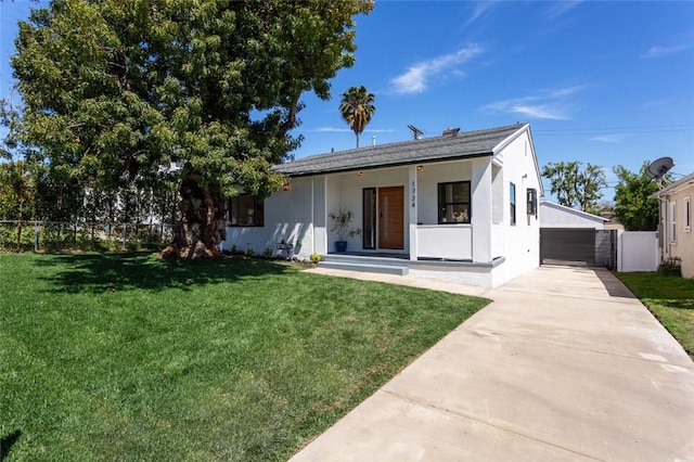 view of front facade with fence, a front lawn, and stucco siding