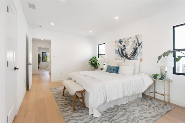 bedroom featuring baseboards, light wood-style floors, visible vents, and recessed lighting
