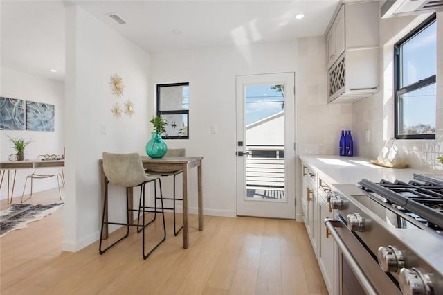 kitchen featuring stainless steel gas stove, visible vents, recessed lighting, and light wood-style floors