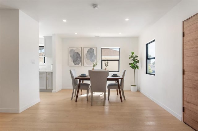 dining space featuring light wood finished floors, baseboards, and recessed lighting