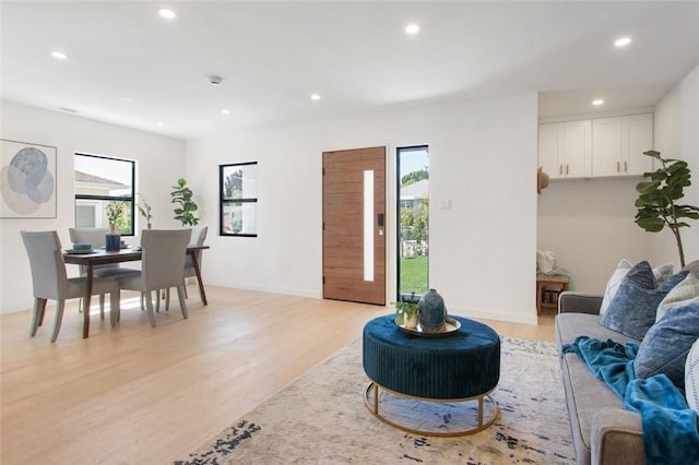 living area with plenty of natural light, light wood-style flooring, and recessed lighting