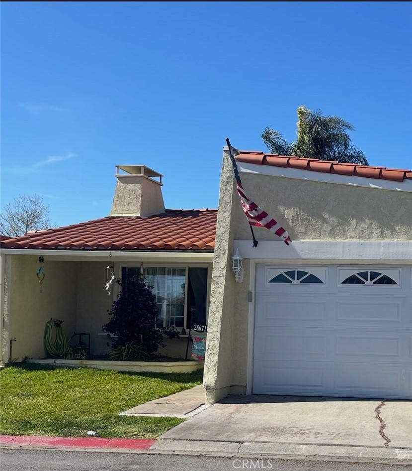 26671 Paseo Tecate, San Juan Capistrano, CA 92675 - view of front of home with a tile roof, a garage, a chimney, a front yard, and stucco siding