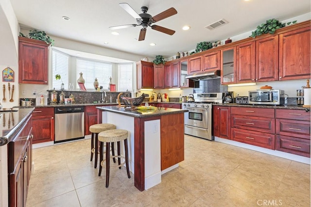 kitchen with dark brown cabinets, visible vents, under cabinet range hood, and stainless steel appliances