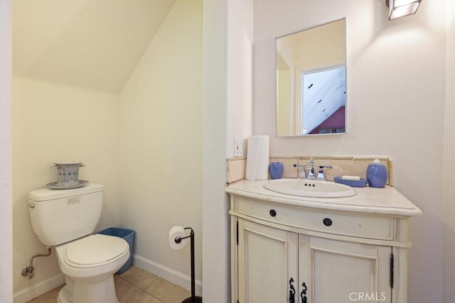 half bathroom with tile patterned floors, vanity, and toilet
