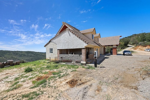 view of property exterior with stucco siding and stone siding