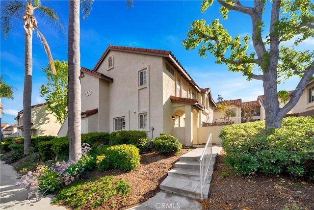 mediterranean / spanish-style house with stucco siding and a tile roof