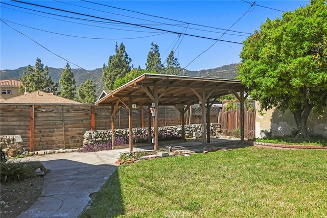 view of yard featuring a mountain view, a fenced backyard, and a gazebo