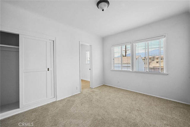 unfurnished bedroom featuring a closet, baseboards, and carpet