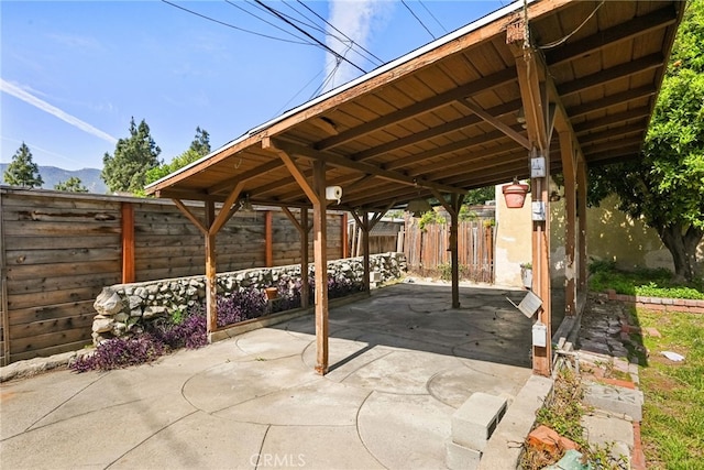 view of patio featuring a carport and fence