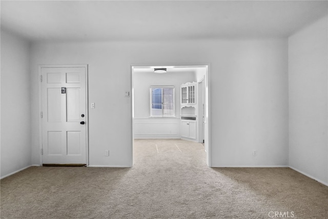 unfurnished room featuring baseboards and carpet