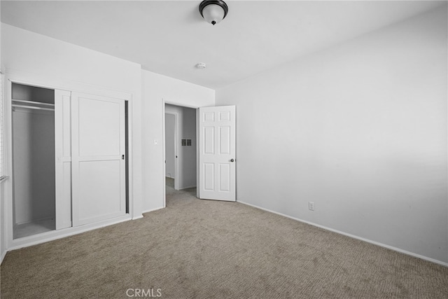 unfurnished bedroom featuring a closet, baseboards, and carpet