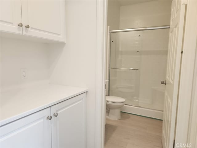 19427 Seeding Palace Cir, Riverside, CA 92507 - full bathroom featuring a shower stall, toilet, wood finished floors, and vanity