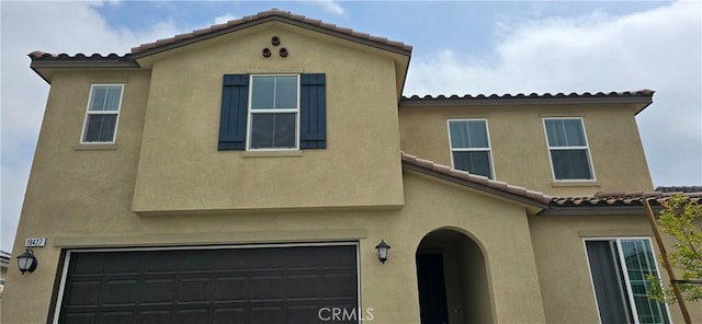 19427 Seeding Palace Cir, Riverside, CA 92507 - view of front of home with a tile roof, an attached garage, and stucco siding