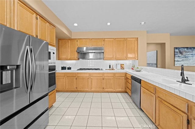 45422 Camino Monzon, Temecula, CA 92592 - kitchen with appliances with stainless steel finishes, a sink, tasteful backsplash, under cabinet range hood, and light tile patterned flooring
