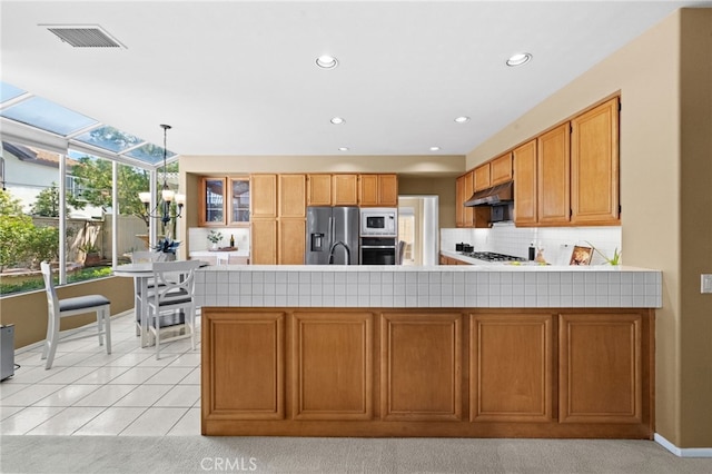 45422 Camino Monzon, Temecula, CA 92592 - kitchen featuring appliances with stainless steel finishes, under cabinet range hood, a peninsula, decorative backsplash, and baseboards