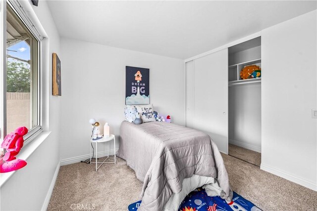bedroom with a closet, carpet, and baseboards
