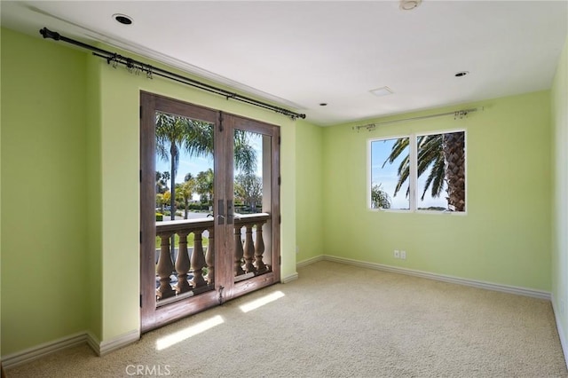 empty room featuring french doors, baseboards, and carpet