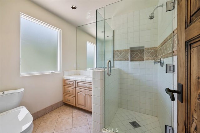 full bathroom featuring vanity, tile patterned flooring, toilet, a stall shower, and baseboards