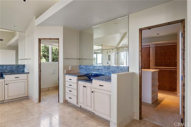 full bathroom with vanity, tile patterned flooring, visible vents, baseboards, and backsplash