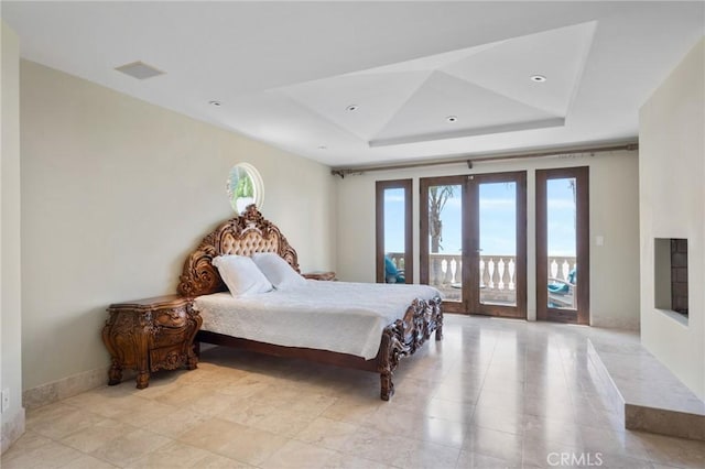 bedroom featuring access to outside, multiple windows, a tray ceiling, and french doors