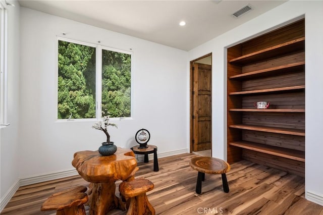 living area featuring visible vents, baseboards, recessed lighting, and wood finished floors