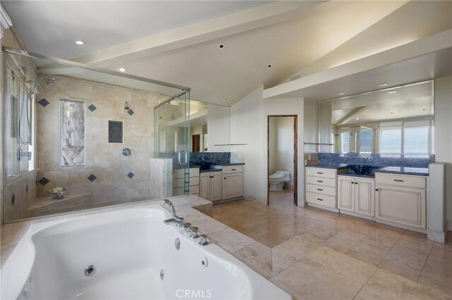 bathroom with a jetted tub, vanity, toilet, a shower stall, and lofted ceiling