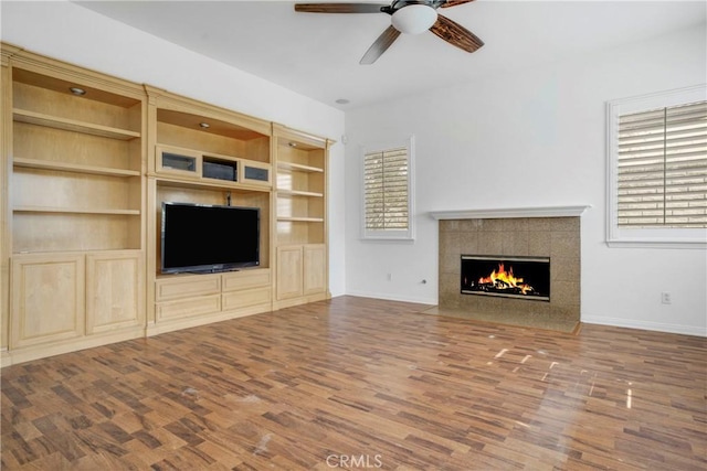 28514 High Ridge Dr, Saugus, CA 91390 - unfurnished living room featuring built in shelves, baseboards, ceiling fan, a fireplace, and wood finished floors