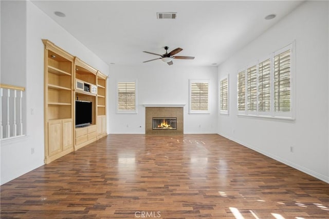 28514 High Ridge Dr, Saugus, CA 91390 - unfurnished living room featuring a glass covered fireplace, baseboards, dark wood-type flooring, visible vents, and ceiling fan