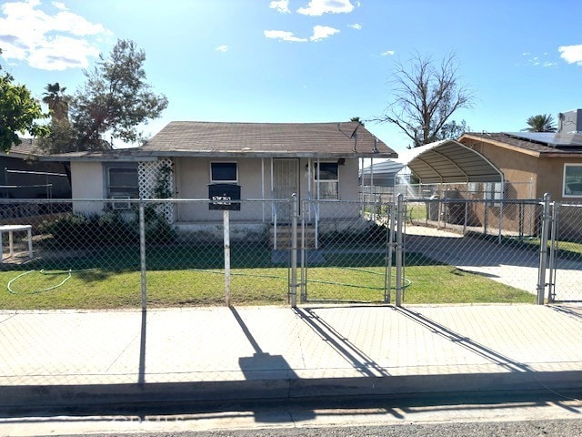 343 S Spring St, Blythe, CA 92225 - view of front of property featuring a fenced front yard, a detached carport, stucco siding, a front lawn, and a gate