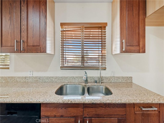 14435 Hopi Rd, Apple Valley, CA 92307 - kitchen featuring light stone counters, brown cabinetry, and a sink