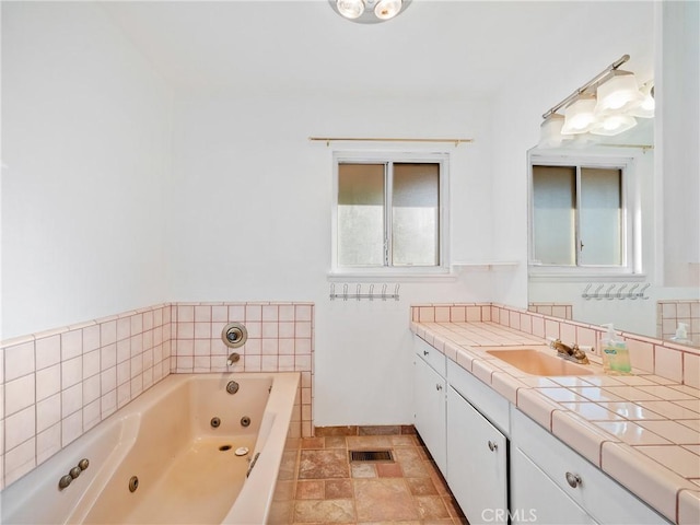 14435 Hopi Rd, Apple Valley, CA 92307 - full bathroom with visible vents, a whirlpool tub, vanity, and stone finish floor
