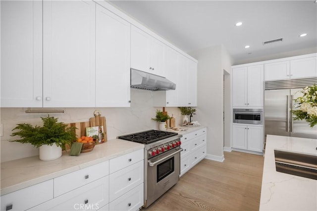 108 Hyperion, Irvine, CA 92618 - kitchen featuring tasteful backsplash, premium appliances, under cabinet range hood, visible vents, and recessed lighting