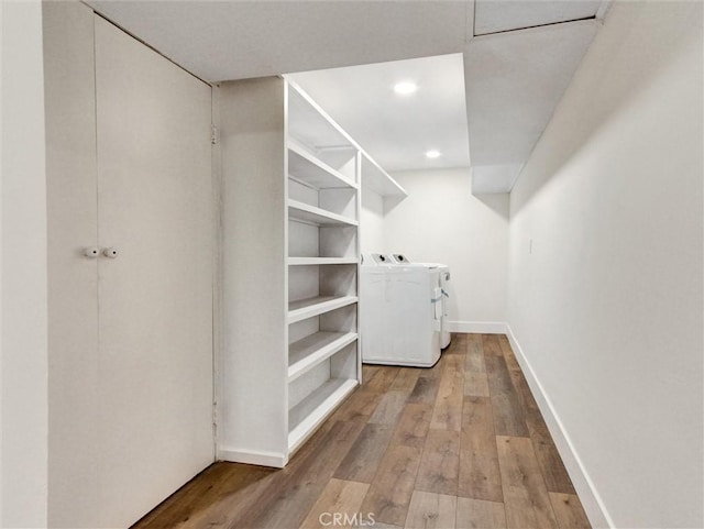 walk in closet with light wood-type flooring and washing machine and clothes dryer
