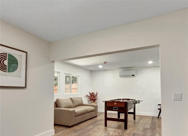 playroom with light wood-style floors, a wall unit AC, baseboards, and recessed lighting