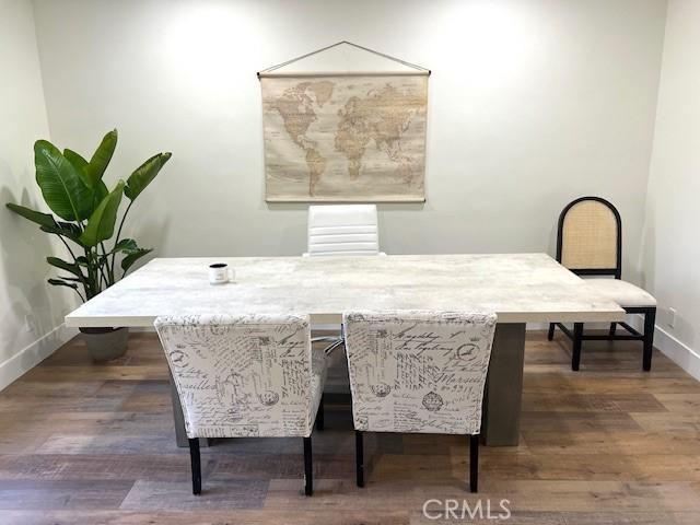 dining area featuring dark wood-style floors and baseboards
