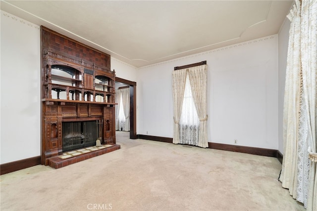 unfurnished living room featuring baseboards, carpet flooring, and a fireplace