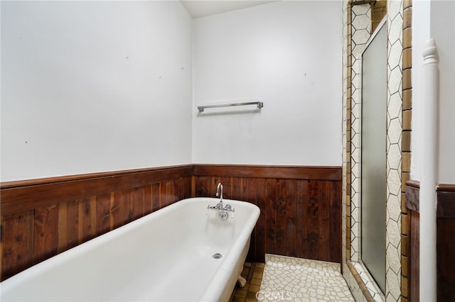 full bathroom with a freestanding tub and wainscoting