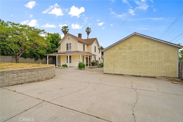 exterior space with a chimney, covered porch, and fence